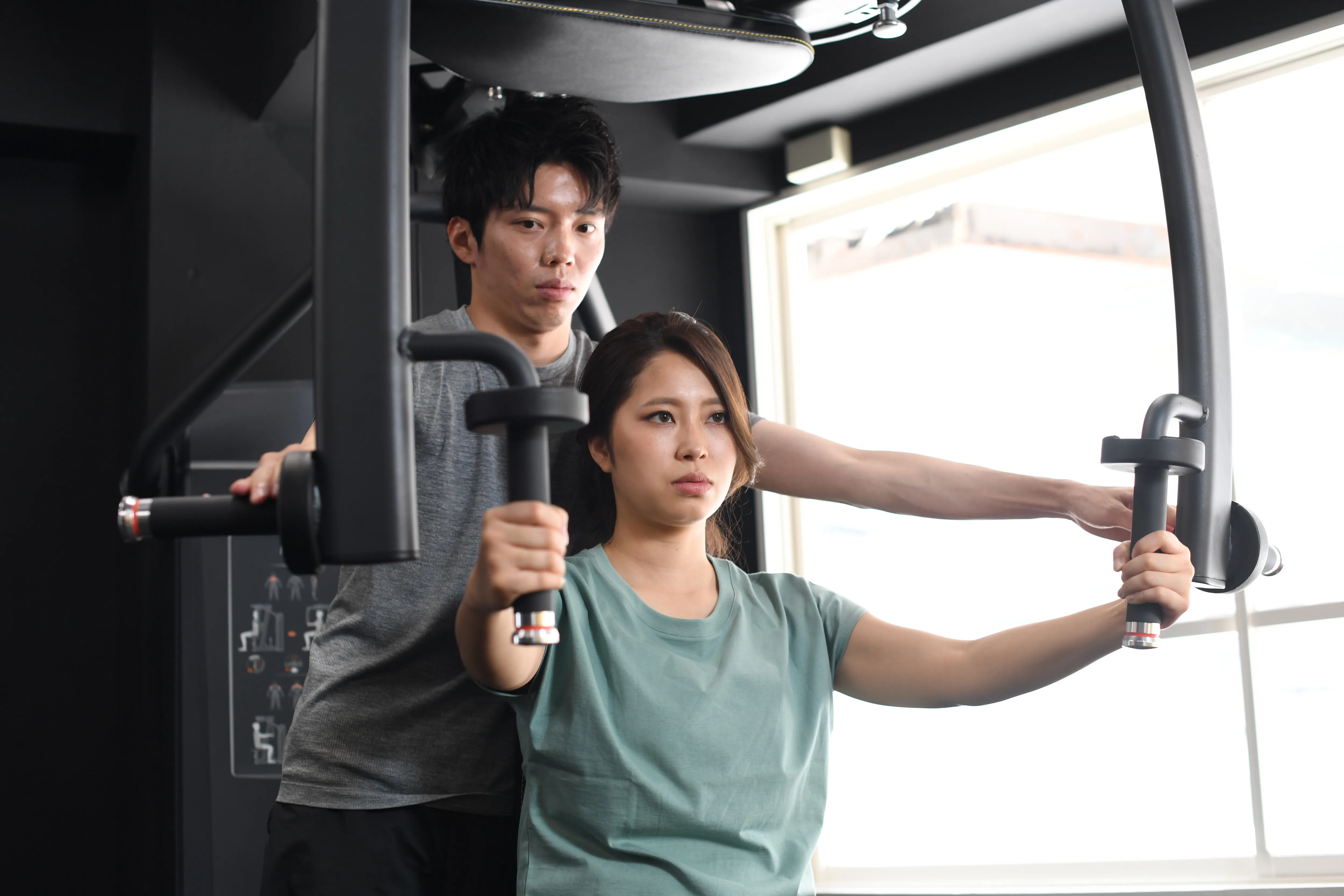 トレーナーがマシンの使い方を説明している様子